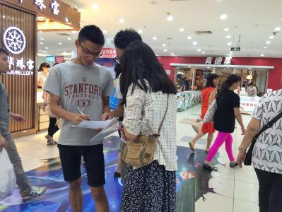 (图为小组成员正在进行问卷调查。)